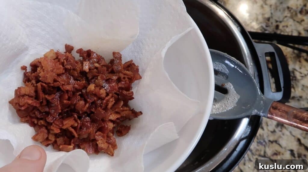 Cooked bacon in paper towel-lined bowl.