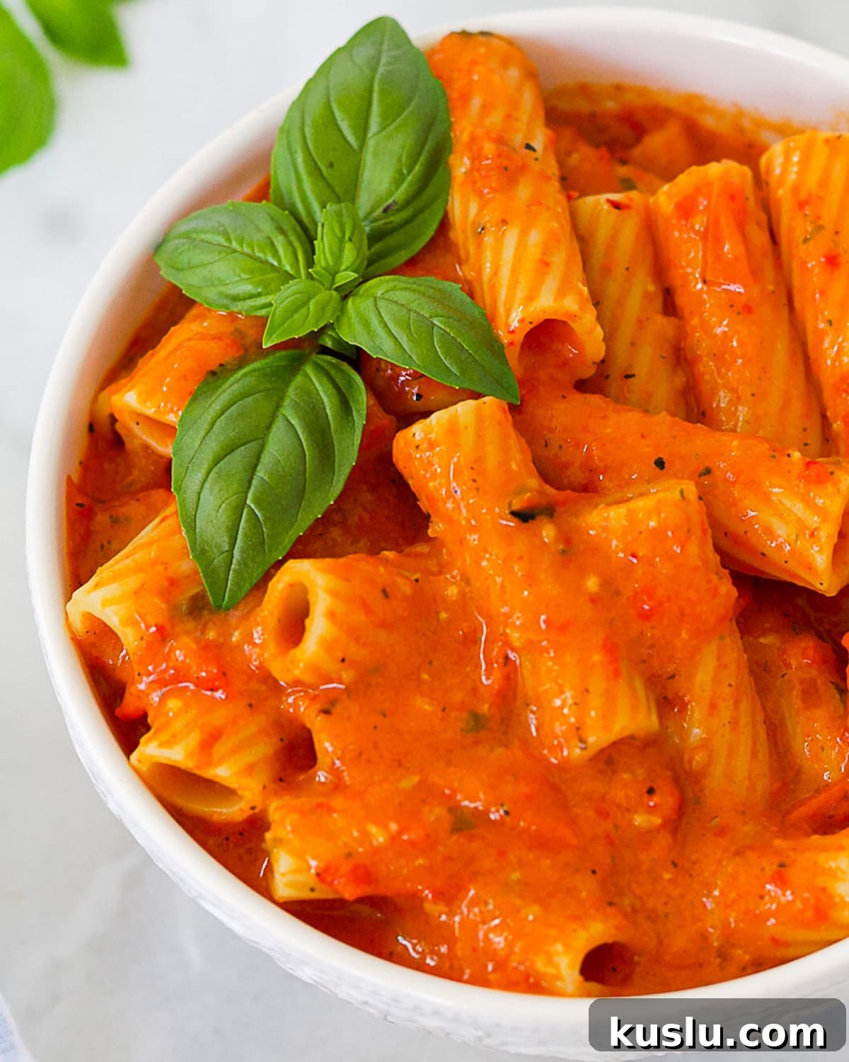 A close up shot of rigatoni noodles covered in pepper pasta sauce