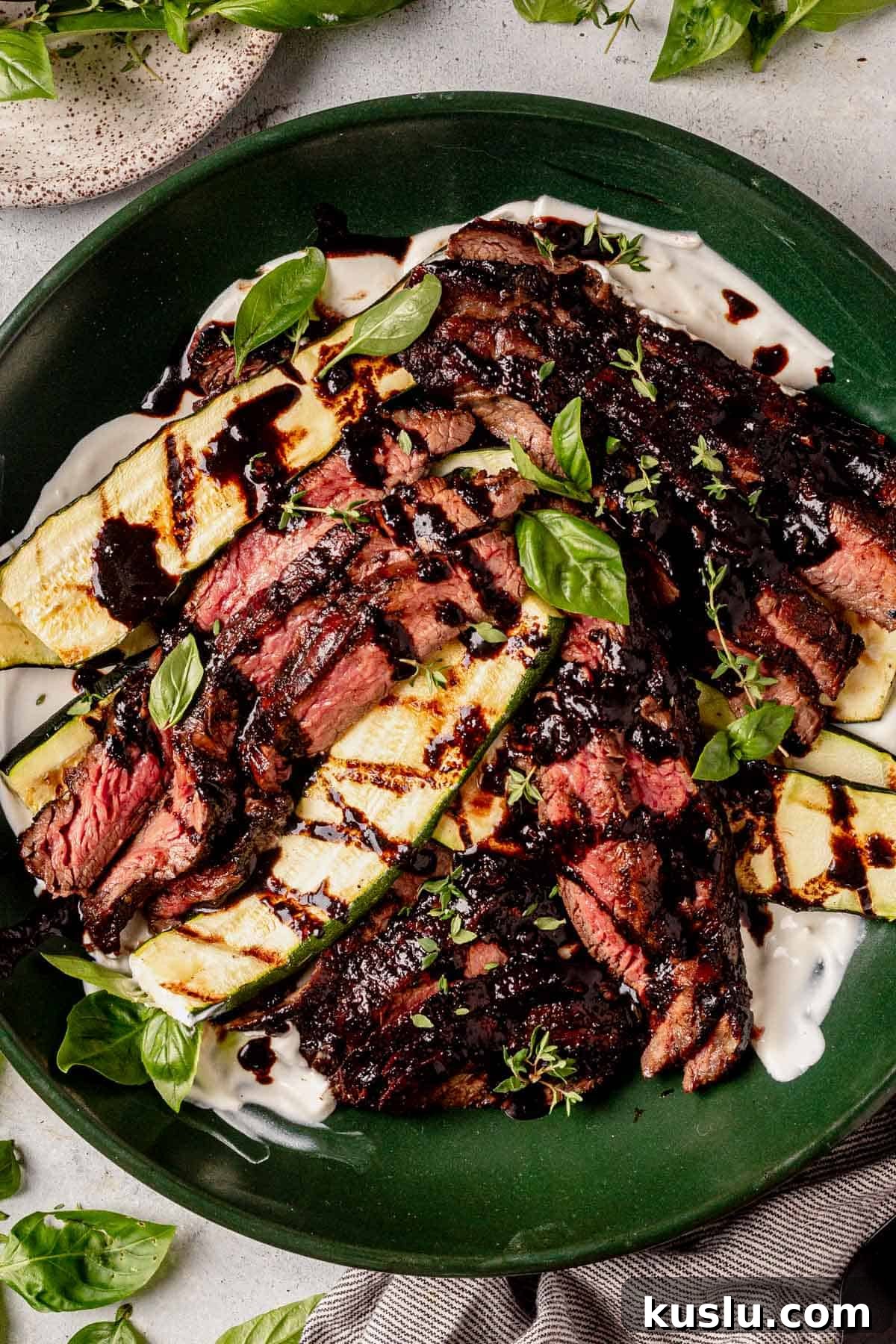 balsamic flank steak thinly sliced in a serving bowl with zucchini