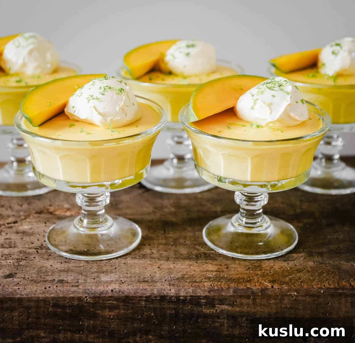 glass bowls of mango pudding on a wooden table