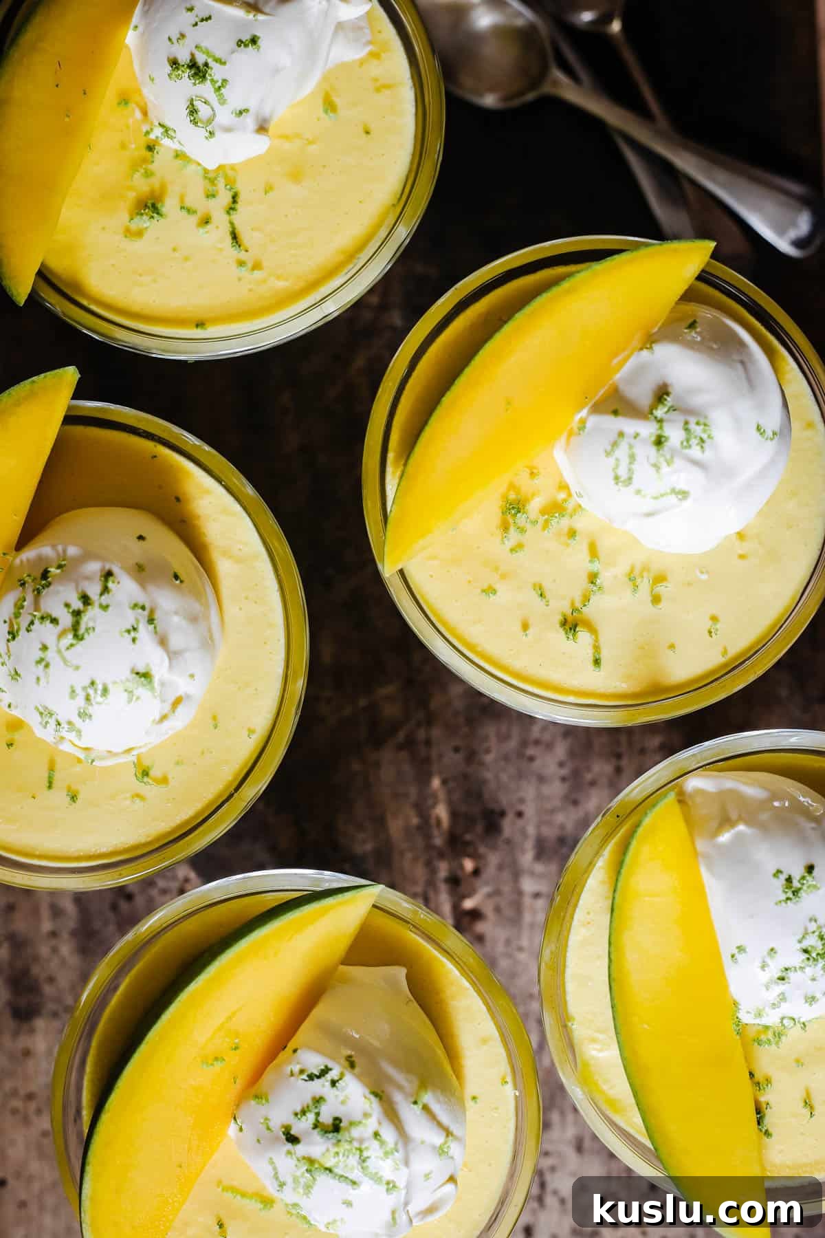 glass bowls of mango pudding on a wooden table