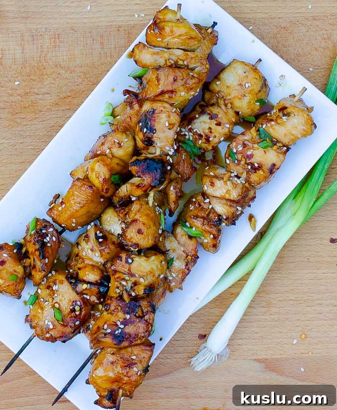four Grilled Asian Chicken Kabobs on a white platter