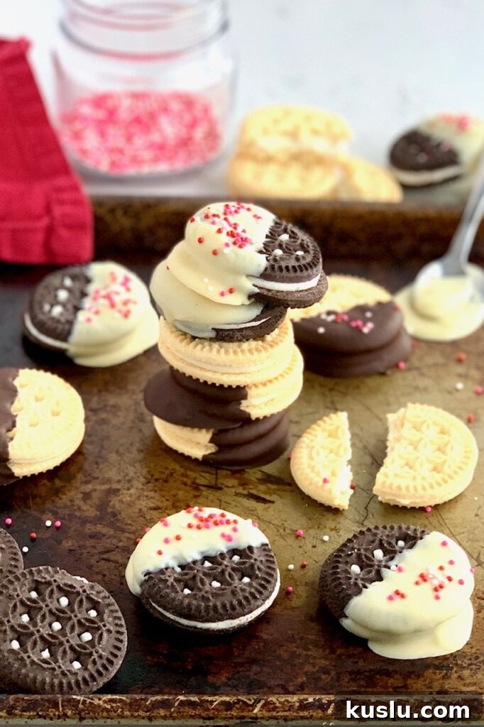 A sheet pan full of GF DF oreos half dipped in white chocolate or chocolate then topped with sprinkles. 