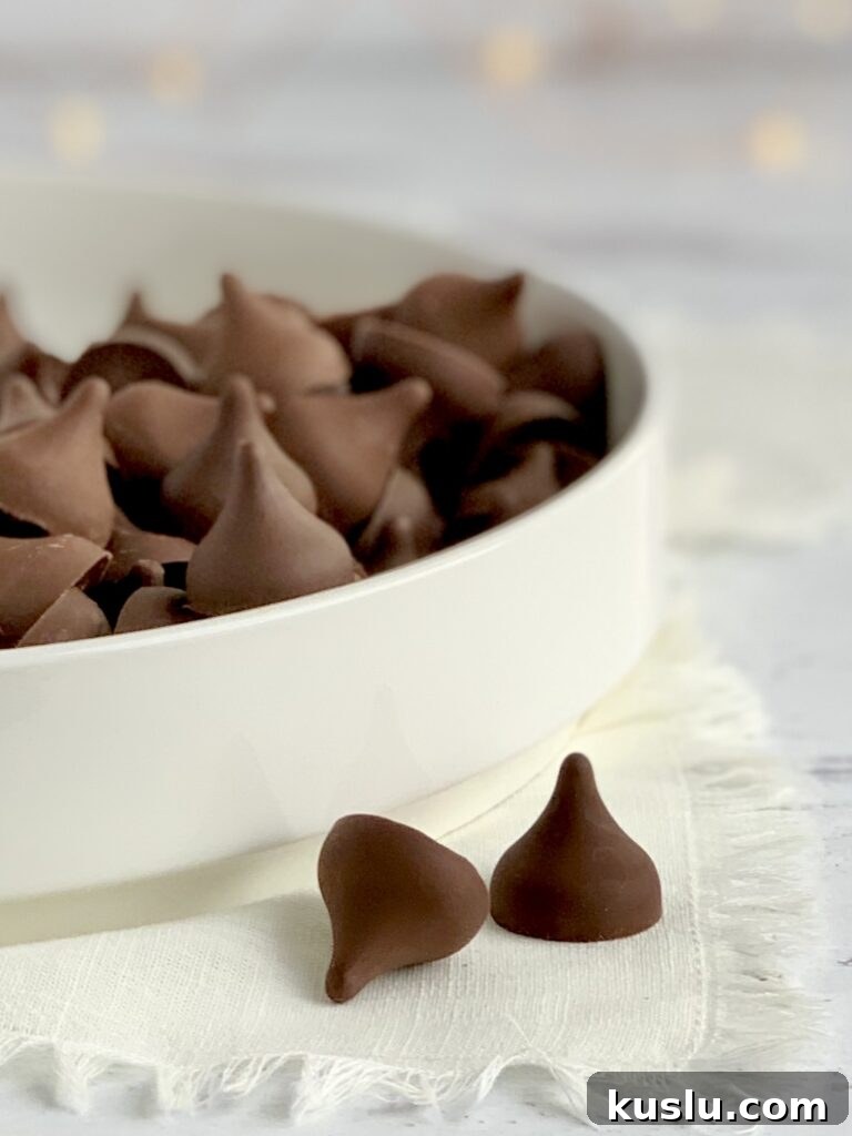 A white platter full of chocolate kisses.